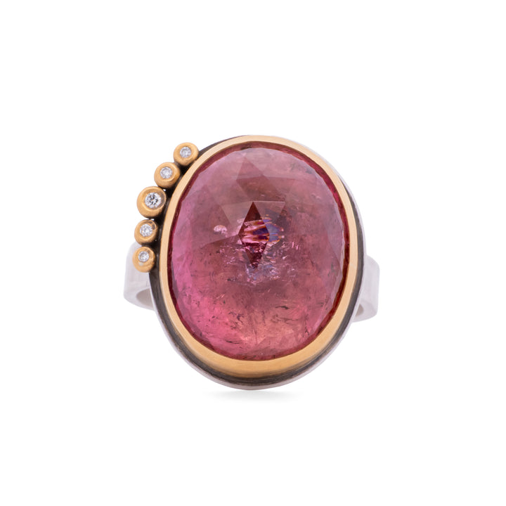 Ring with a pink tourmaline and gold accents on a white background